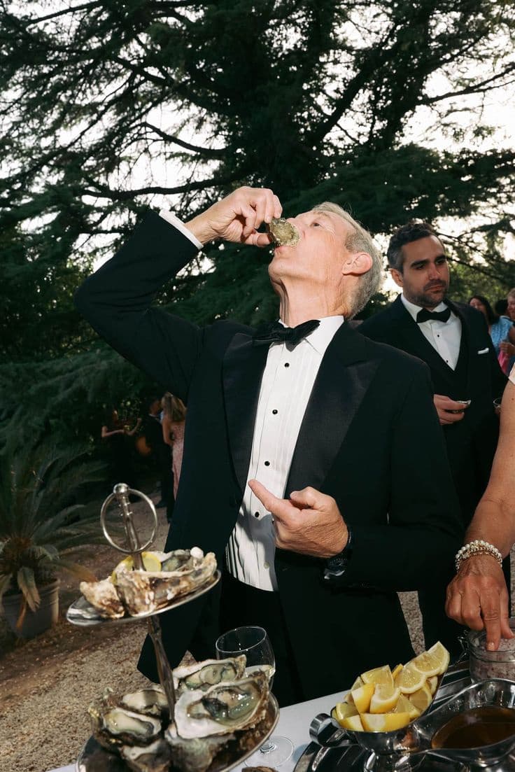 Invitado de esmoquin comiendo una ostra